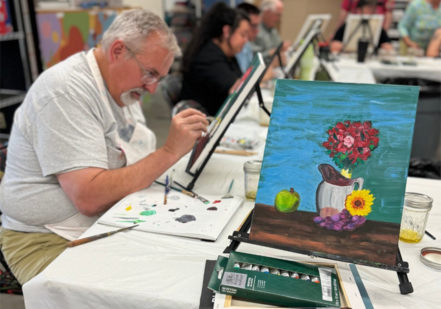 Adult student working on painting in class