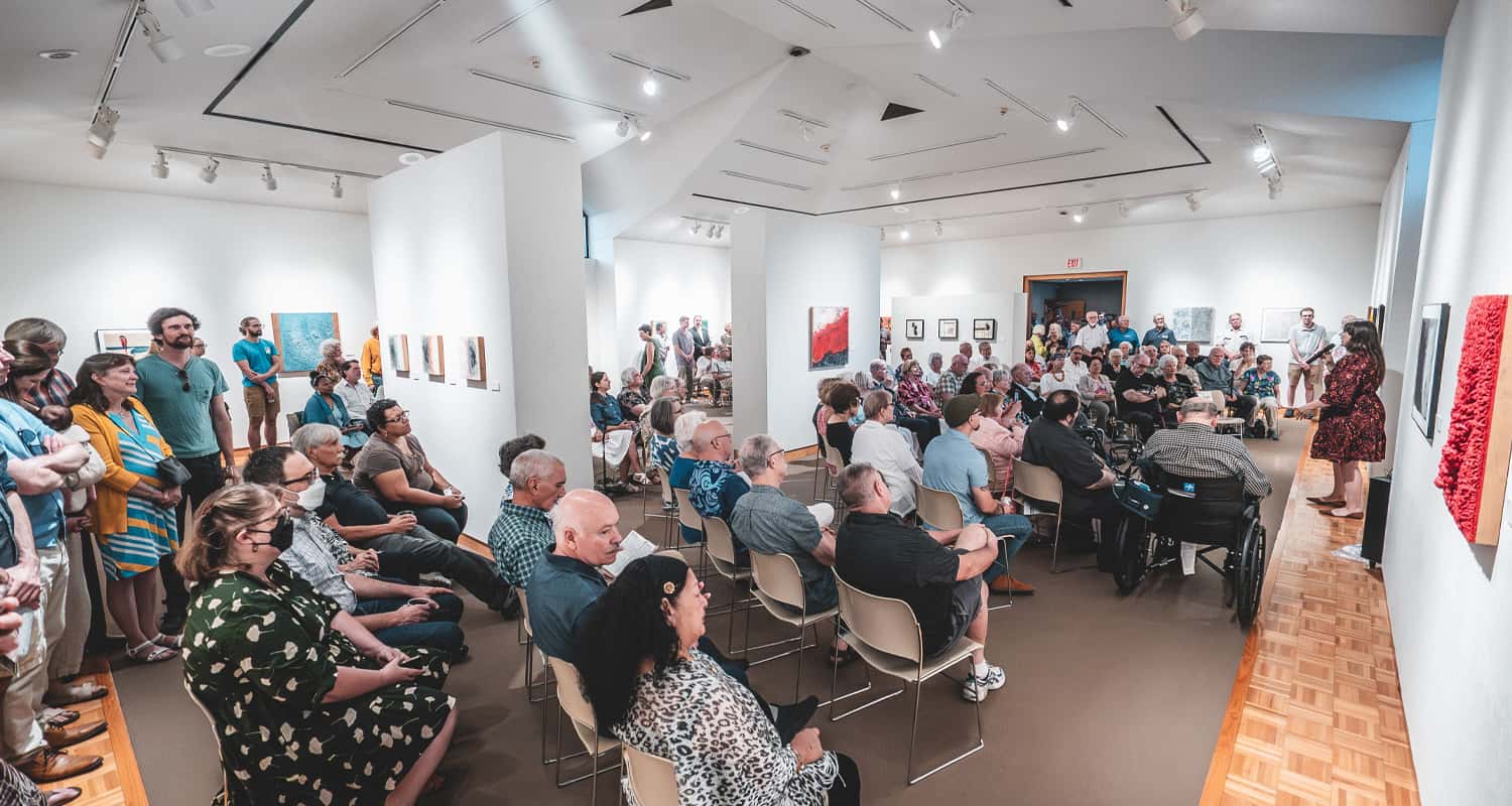 Woman giving talk to crowd at art show